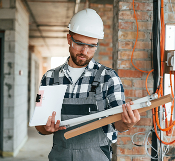 Man with white hard hat holding tube bulbs