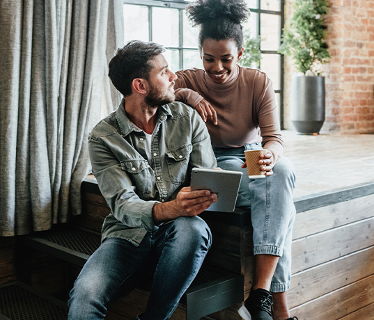 Young woman and man looking at tablet device