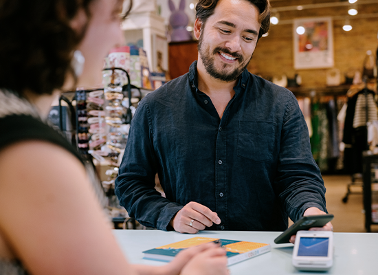 Customer taps a payment card on a point-of-sale terminal during a purchase transaction.