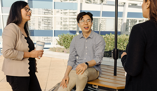 Man sitting on picnic table smiling with two women