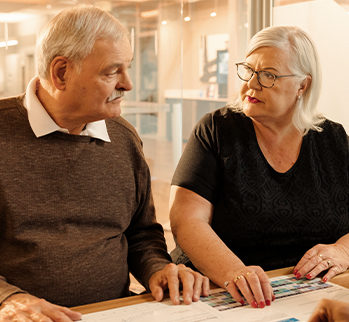An older man and woman sitting looking at each other