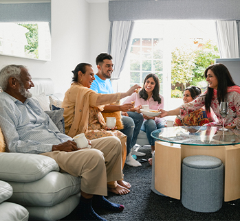 a family is sitting in a living room smiling with each other